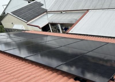 All-black solar array on a terracotta tile roof