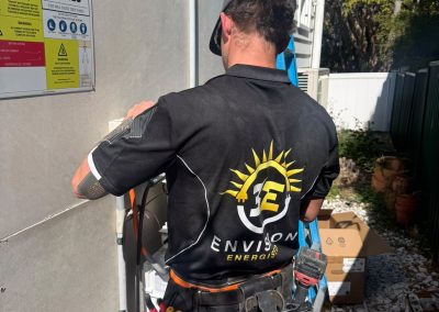 Technician working on an outdoor unit, branded uniform