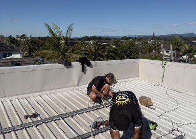 Installers fixing solar mounting rails to a roof
