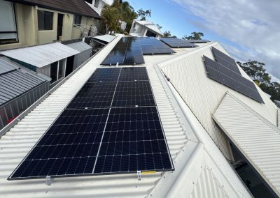 Solar panels across a white corrugated metal roof